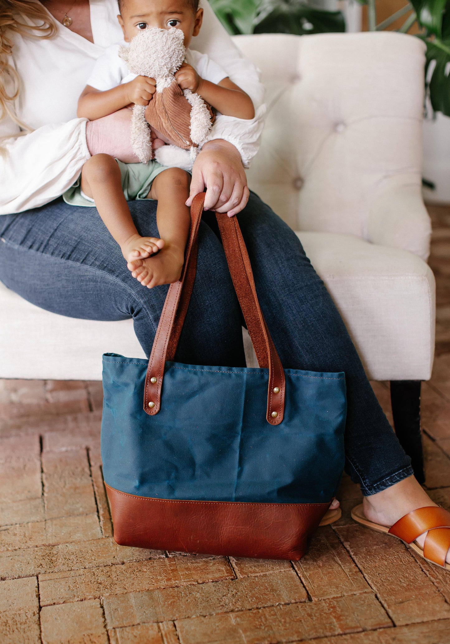 Mother carries Classic Canvas Tote in Sapphire while caring for her baby