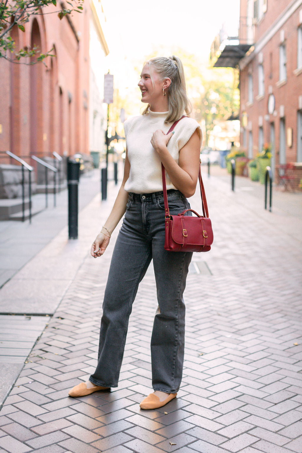 Woman carries the Handmade Leather Carriage Crossbody in Merlot over her shoulder.