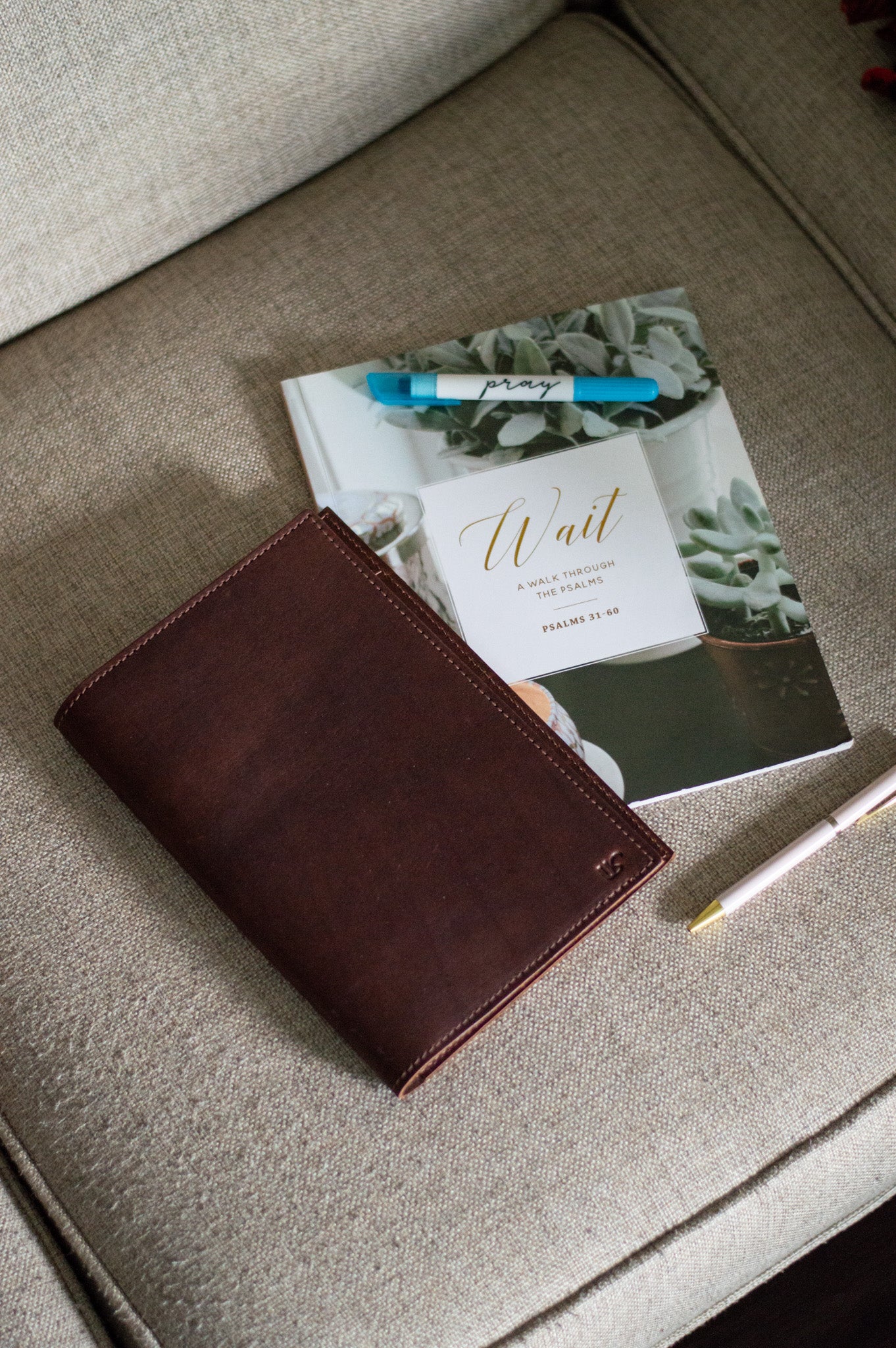 A full-grain leather A5 Journal, lays next to a devotional notebook & pens.