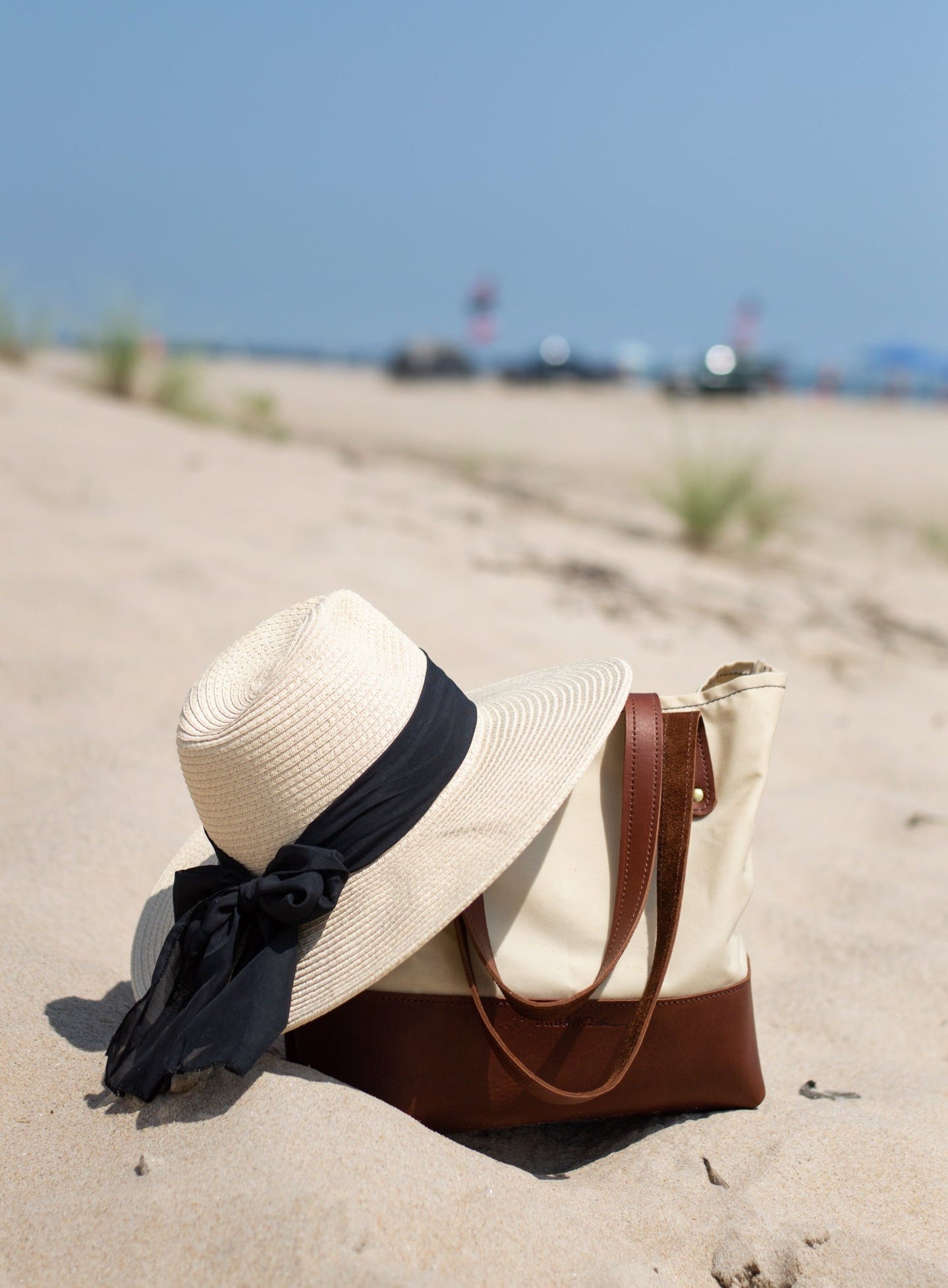 Classic Canvas Tote in Cream sits in the sand on the beach