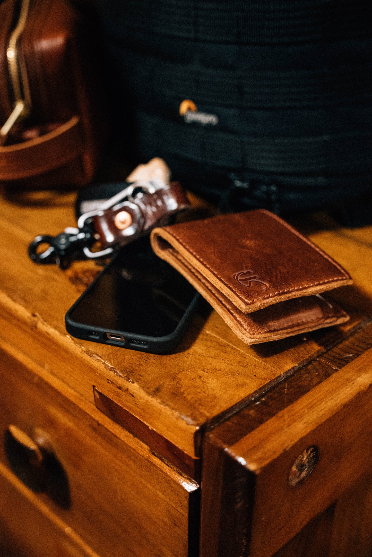 A Bifold Wallet sits on a side table, next to a cellphone & key fob.