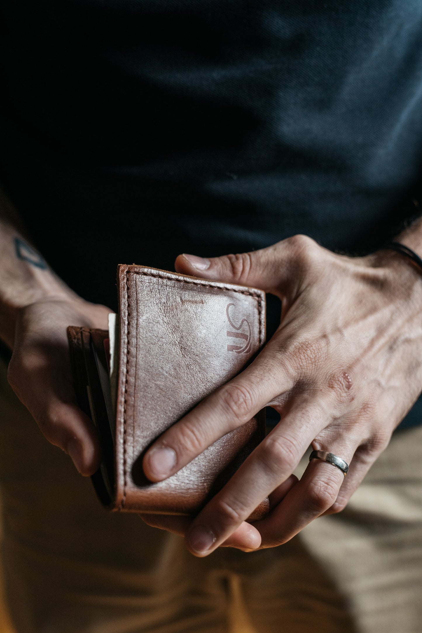 A man holds the bifold Wallet in his hands.