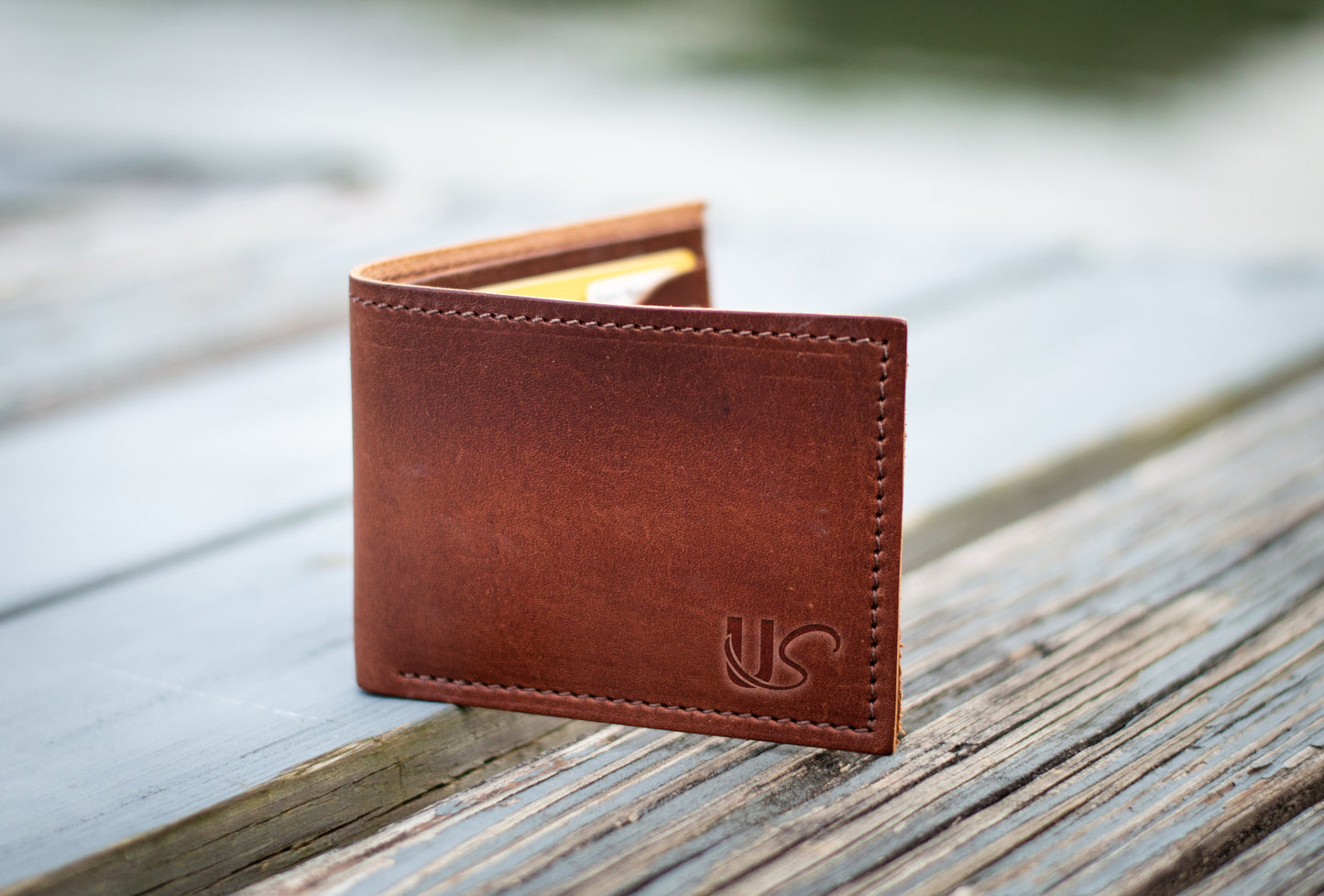 A close up view of the Bifold Wallet as it sits open on a wood dock.