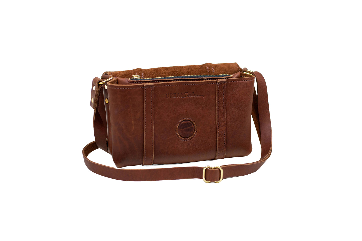 Handmade Leather Carriage Crossbody in Cognac with top flap folded back revealing engraved Urban Southern logo.