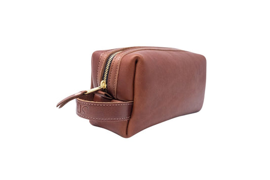 A side angle view of the full-grain leather Dopp Kit. Featuring a brass zipper, copper rivets & a convenient grab handle.