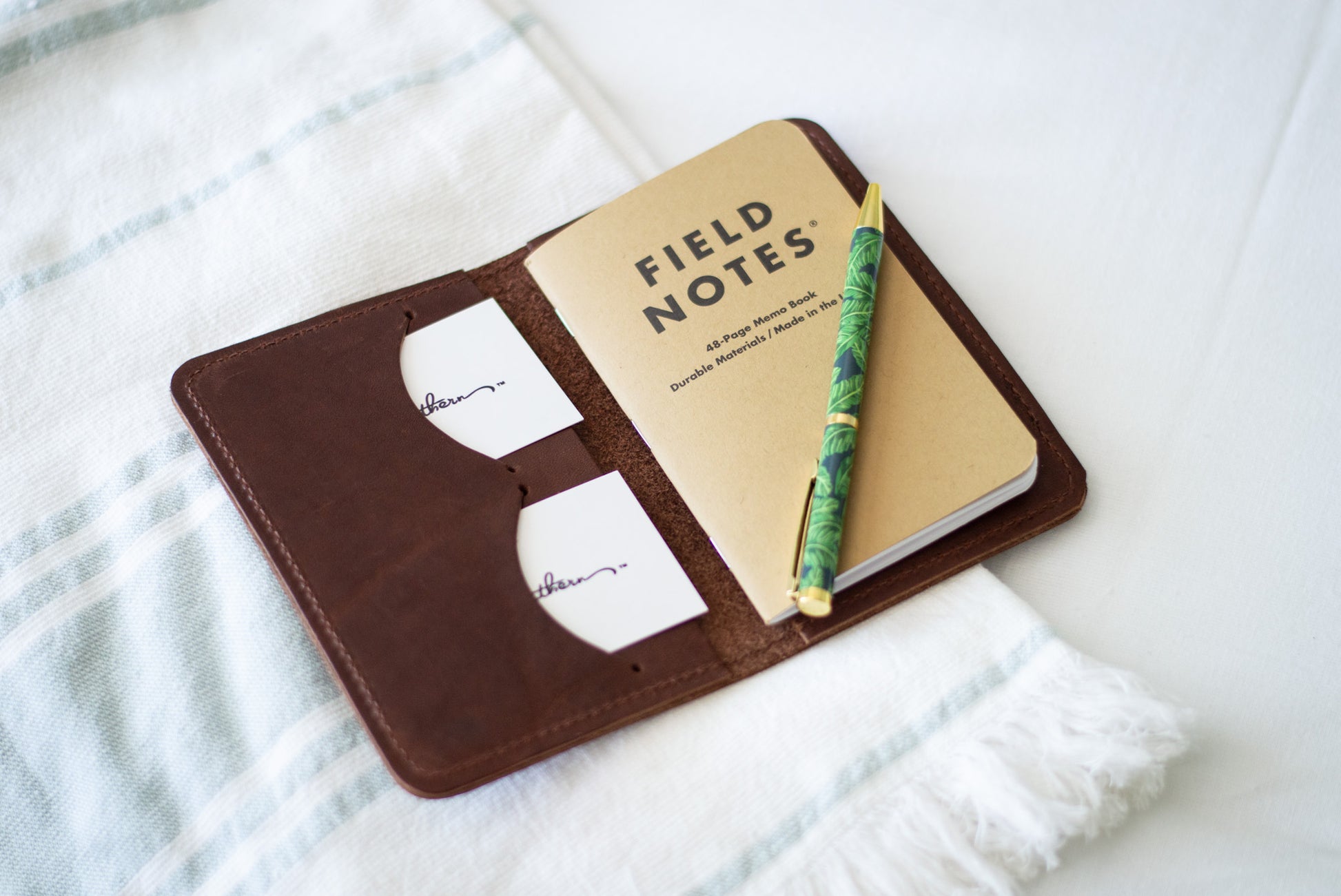 an open notebook wallet showcases its two card slots, filled with business cards.
