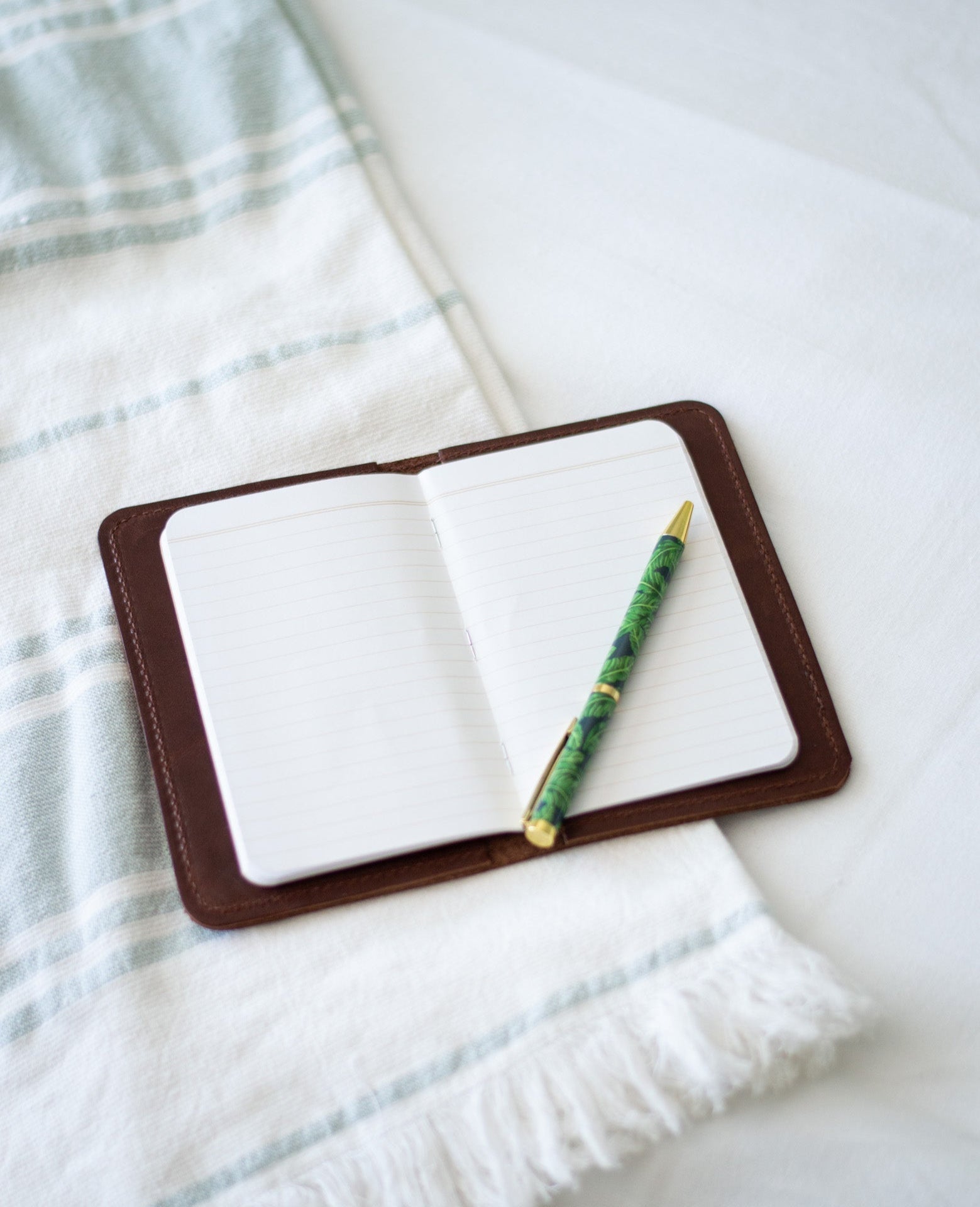 An open leather notebook wallet showcases its 48 page memo book, perfect for taking notes.