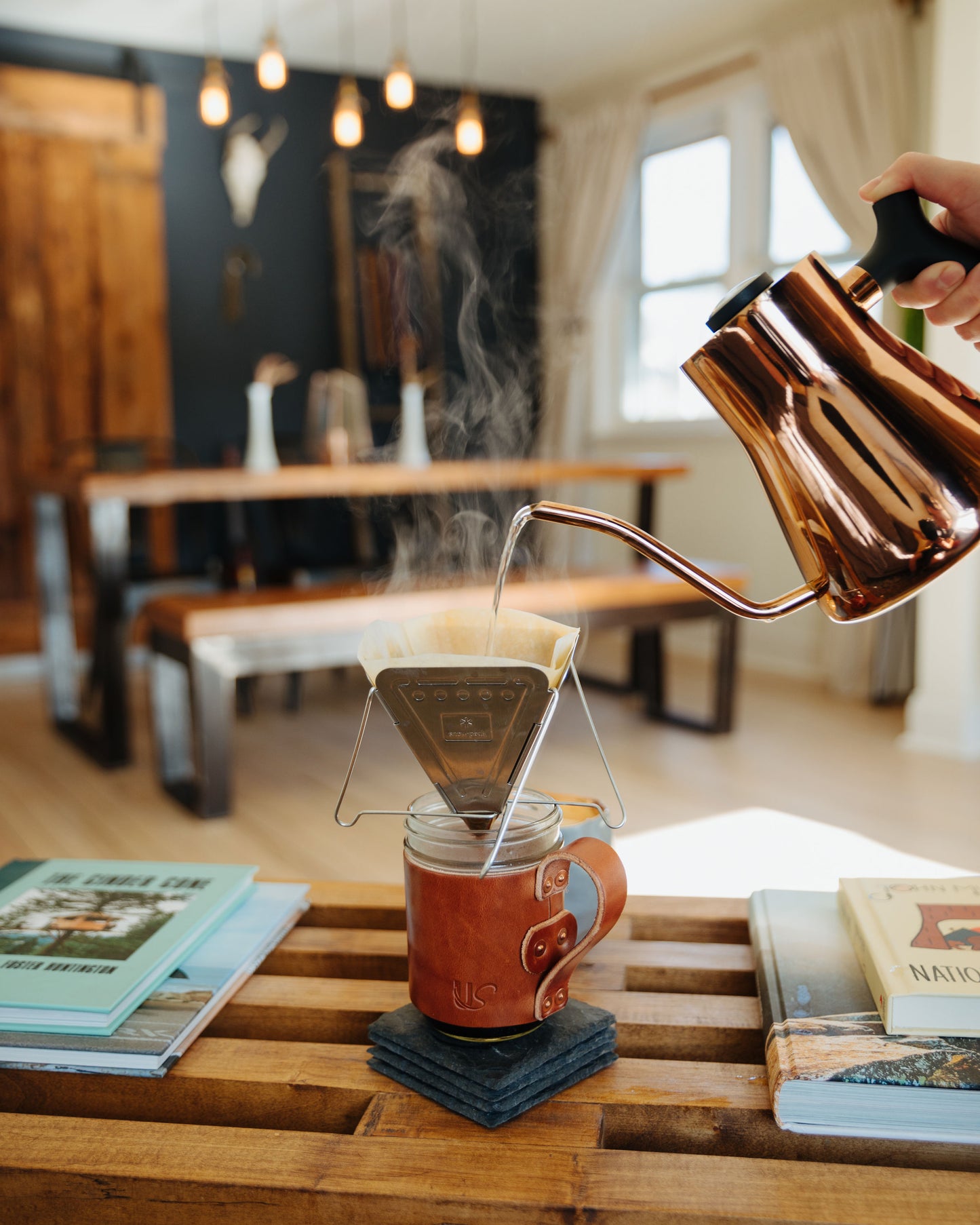 A man prepares his pour-over coffee, over top of a leather wrapped Mason Jar Mug.