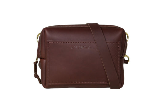 The Urban Sling, featuring full-grain leather, brass hardware, and an adjustable, removable strap.