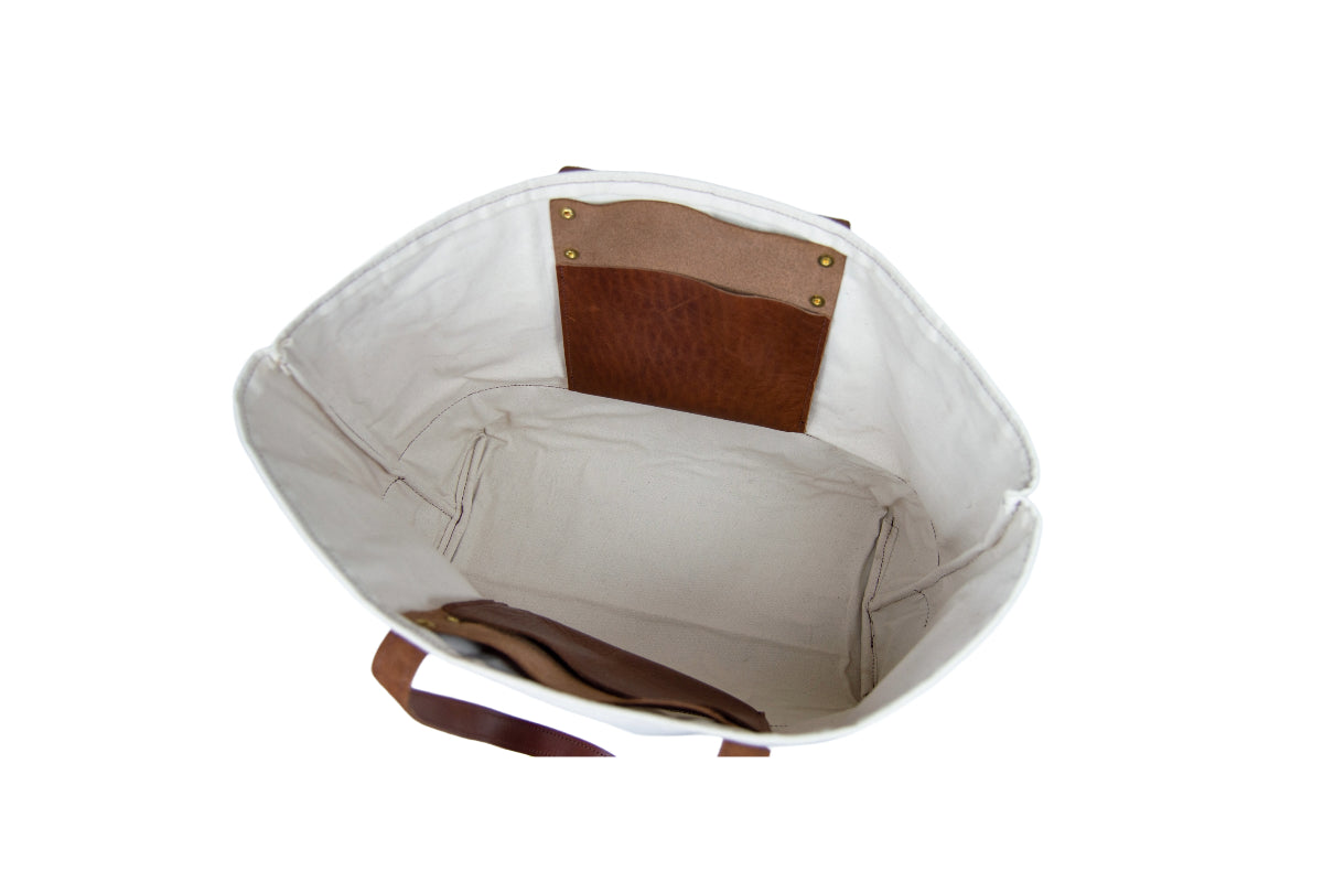 The Urban Southern handcrafted leather Large Canvas Tote features one large storage area plus two leather interior pockets.