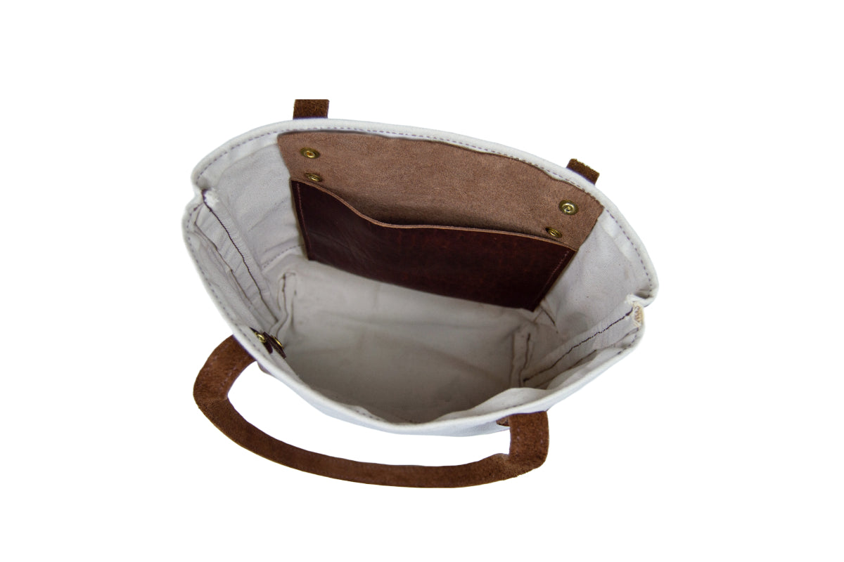 The open storage area and leather pocket inside the Mini Canvas Tote.