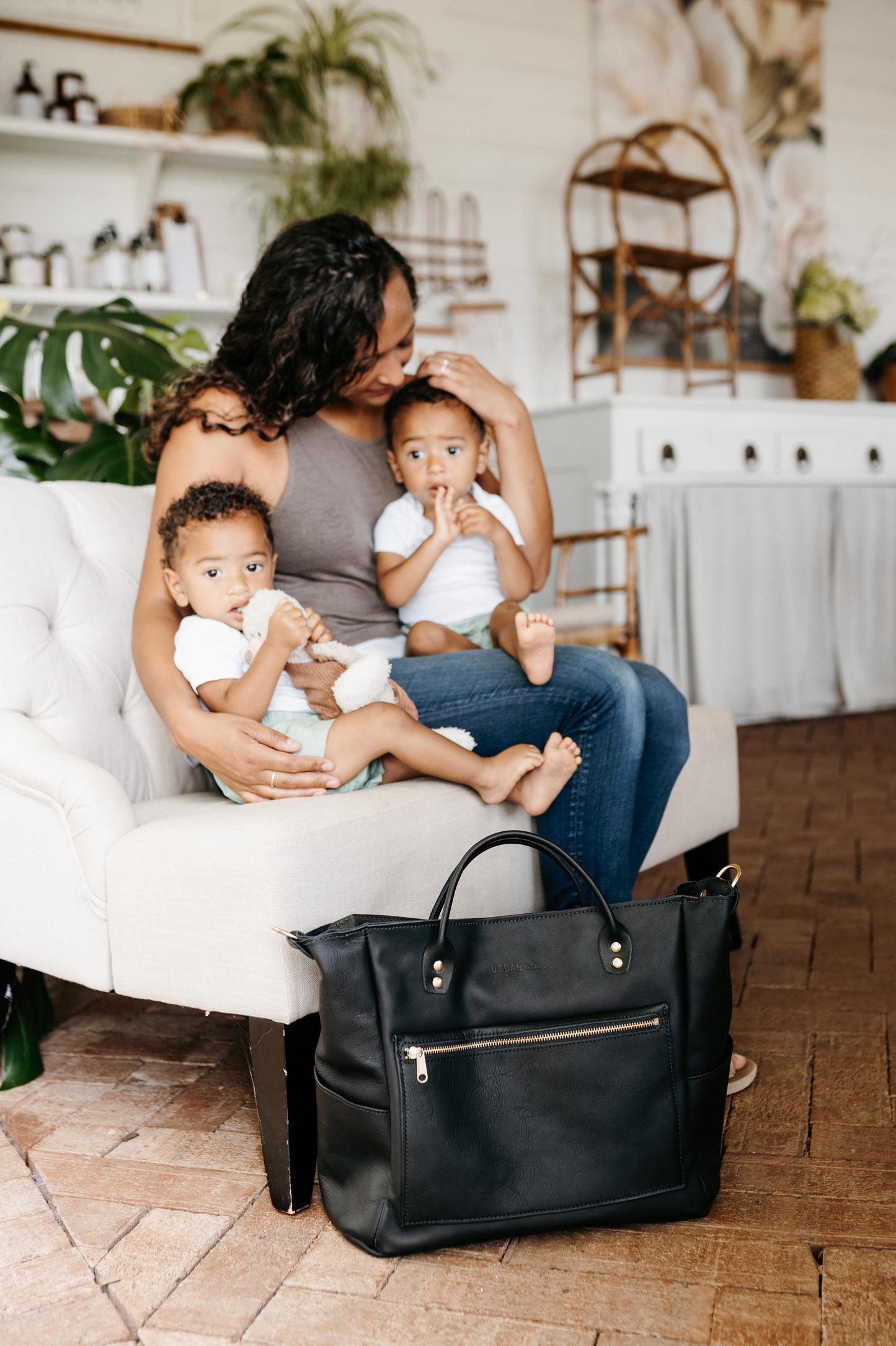 A mother with two small children uses the Legacy Backpack Tote in Black.