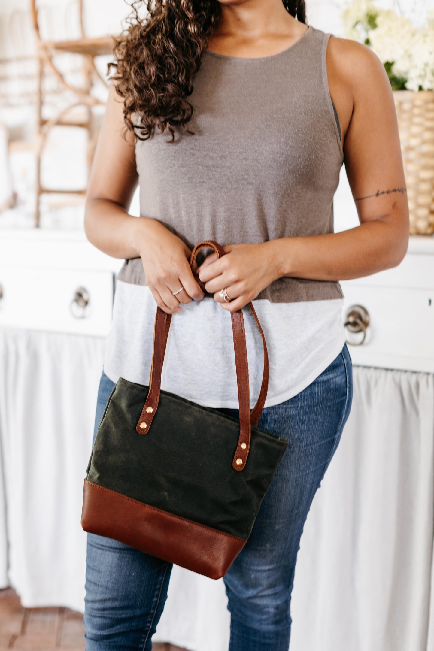 A woman carries the Mini Canvas Tote in Hunter.