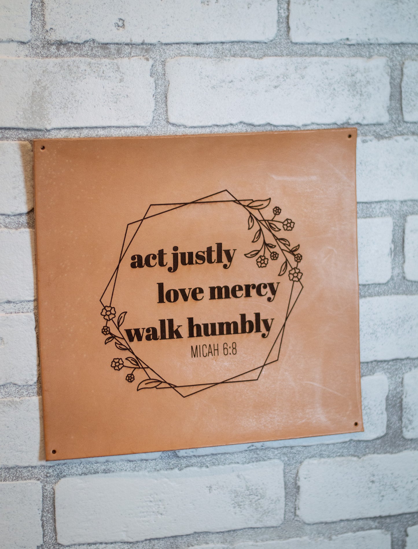 Leather sign mounted on brick wall