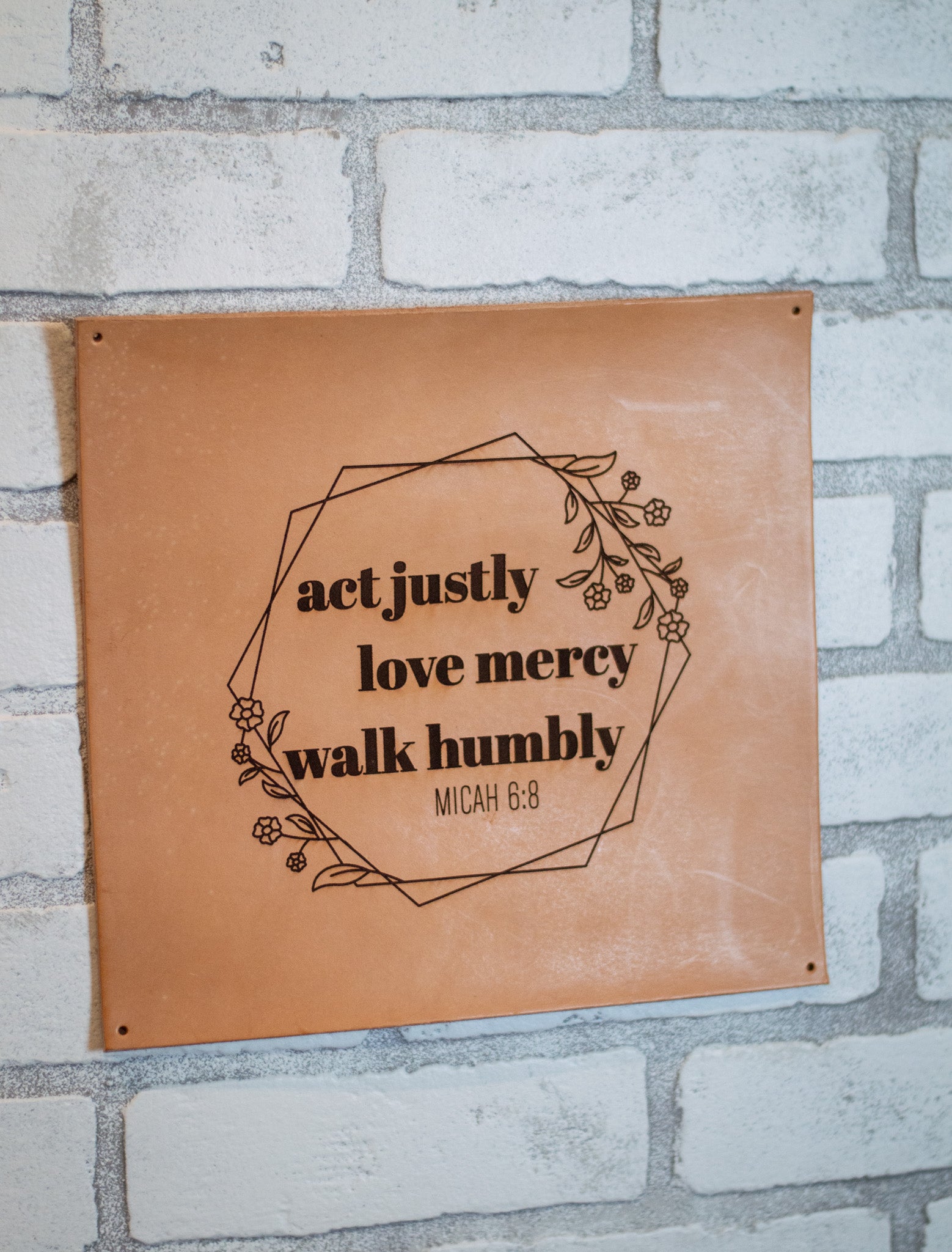 Leather sign mounted on brick wall