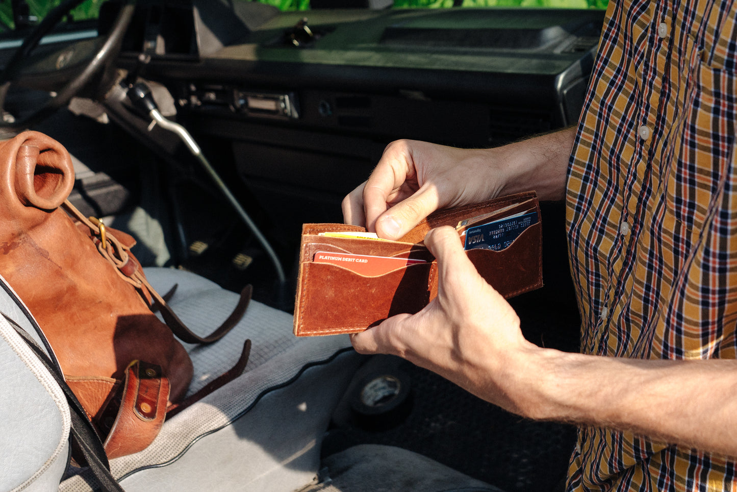 A man opens up a Bifold Wallet, revealing a selection of credit cards in the 4 card slots.