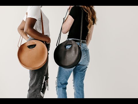 Video tour demonstrating the features of the Britt Circle Crossbody. A woman showcases the interior compartment and magnetic closure.