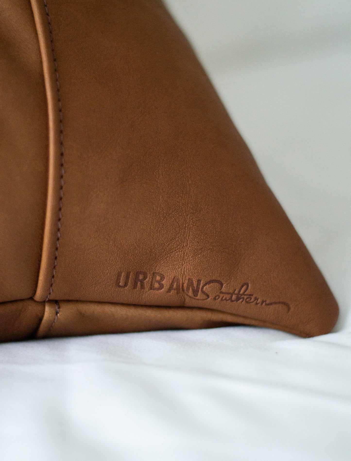 A small Urban Southern logo is engraved on the bottom corners of the pillows.
