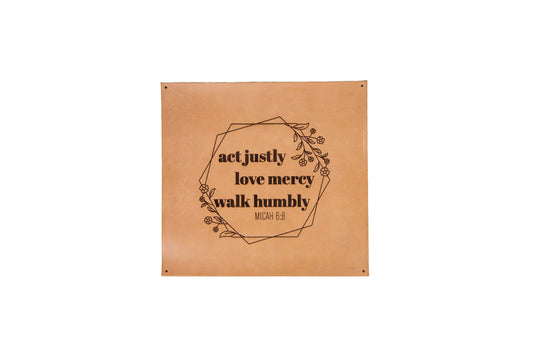 The Urban Southern handcrafted square leather sign features the engraved words, "Act justly, Love mercy, Walk humbly. Micah 6:8" surrounded by engraved flowers and overlapping hexagon outlines.