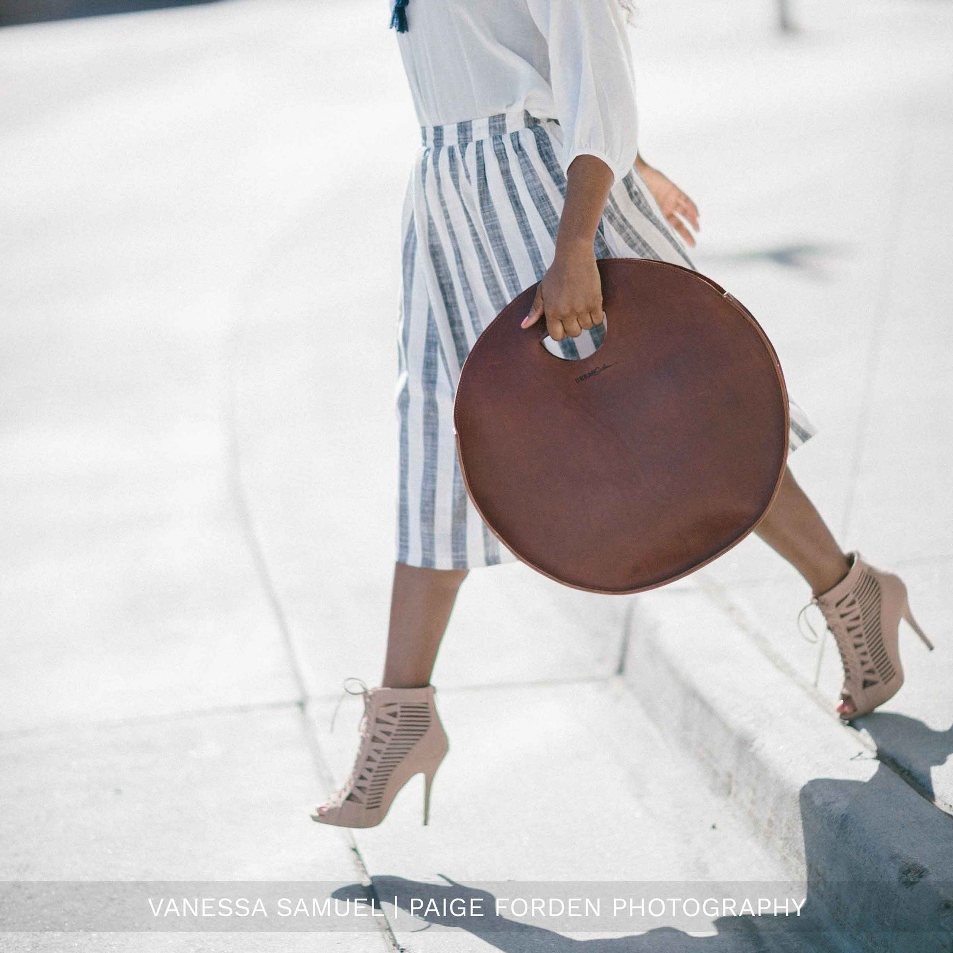 A woman carries the Carrollton Circle Tote in Chestnut Brown.