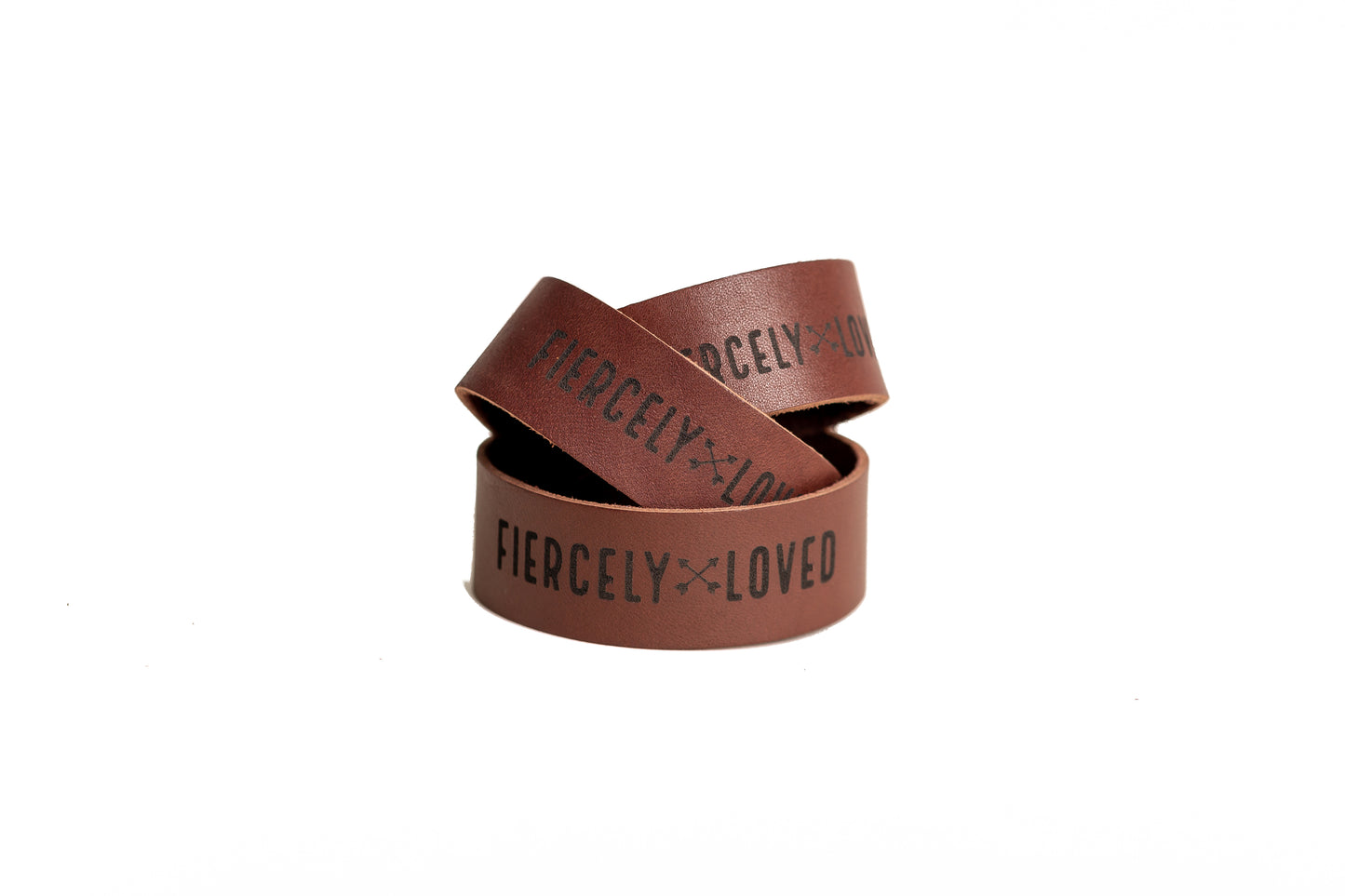 The Urban Southern handcrafted Chestnut Brown leather cuff bracelet includes a brass snap and the engraved words "FIERCELY LOVED" with two arrows crossed in the middle.
