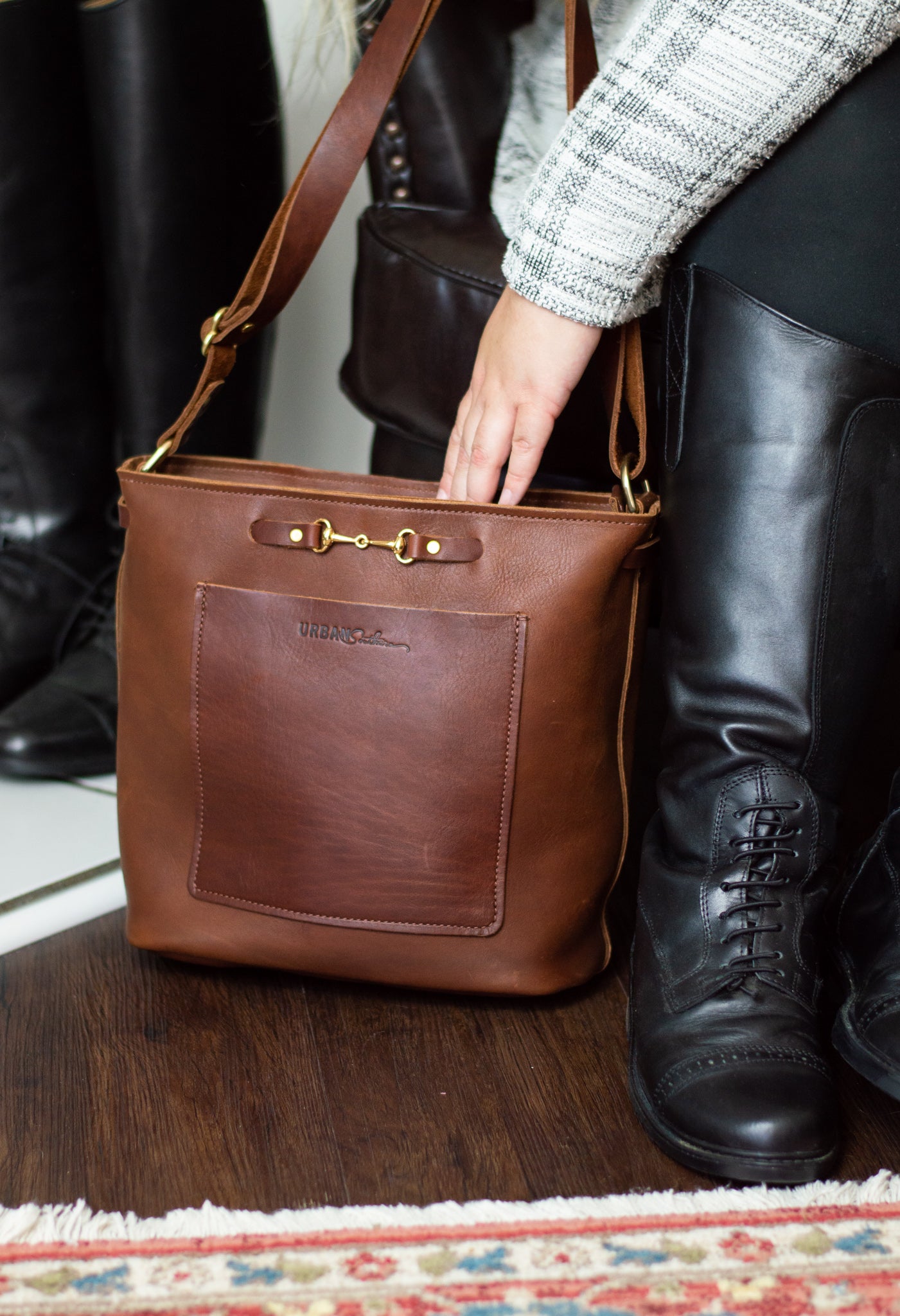 A woman reaches into her cognac Lexington Julep leather handbag.