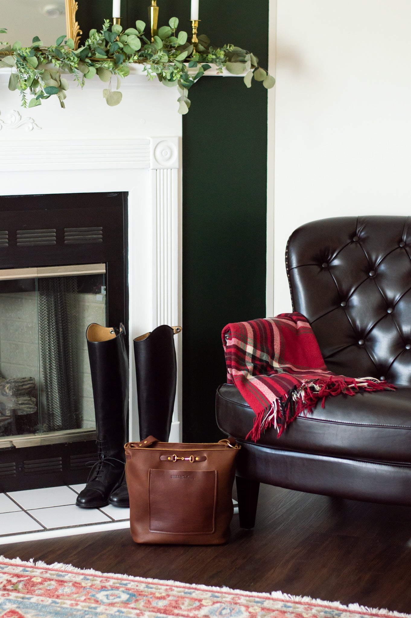 A cognac Lexington Julep leather handbag sits in an equestrian themed living room.