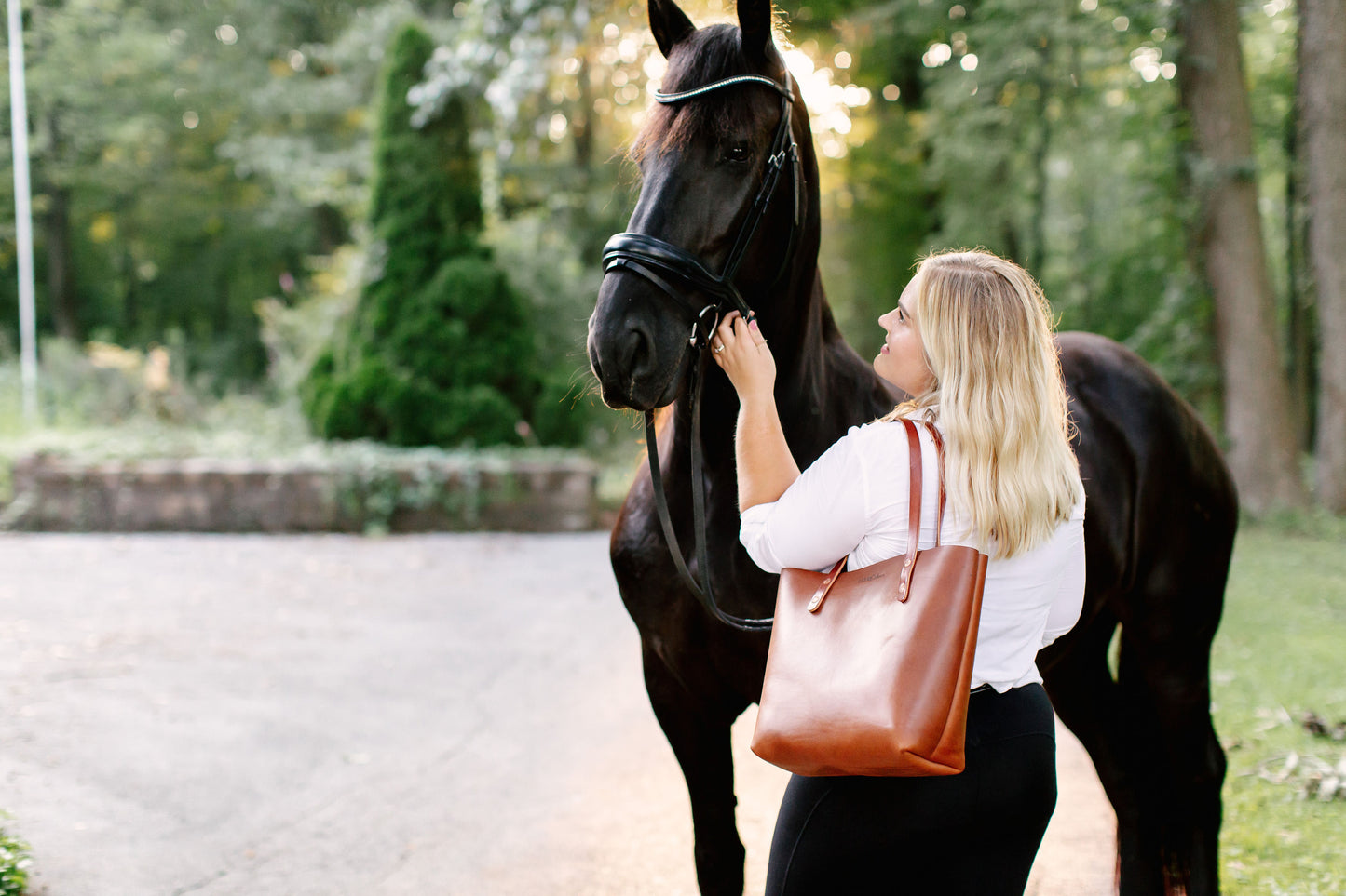 A woman carries the Classic Tote over her shoulder.