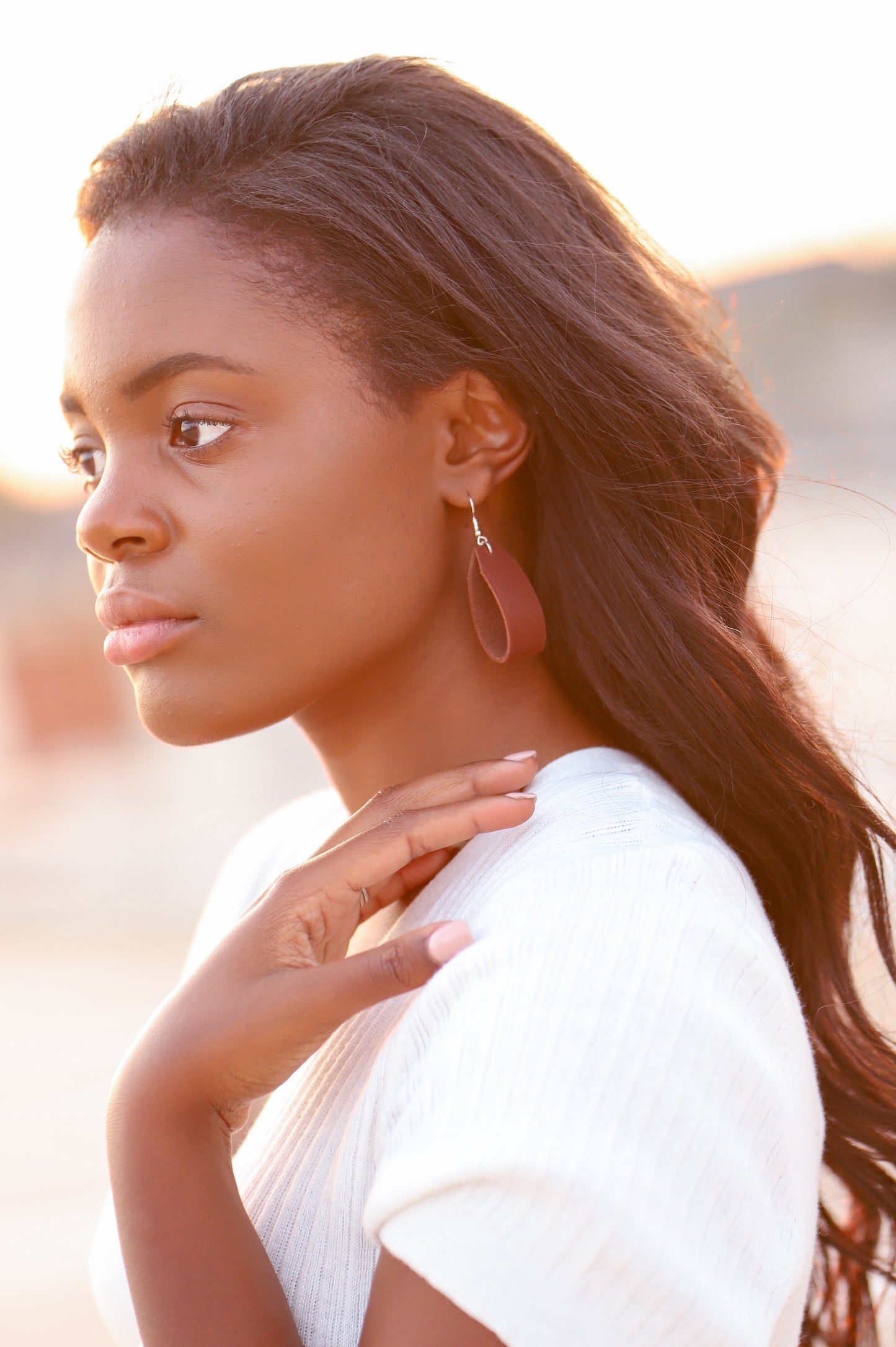 A woman wears the Urban Southern Leather Loop Everyday Earrings in Chestnut Brown.
