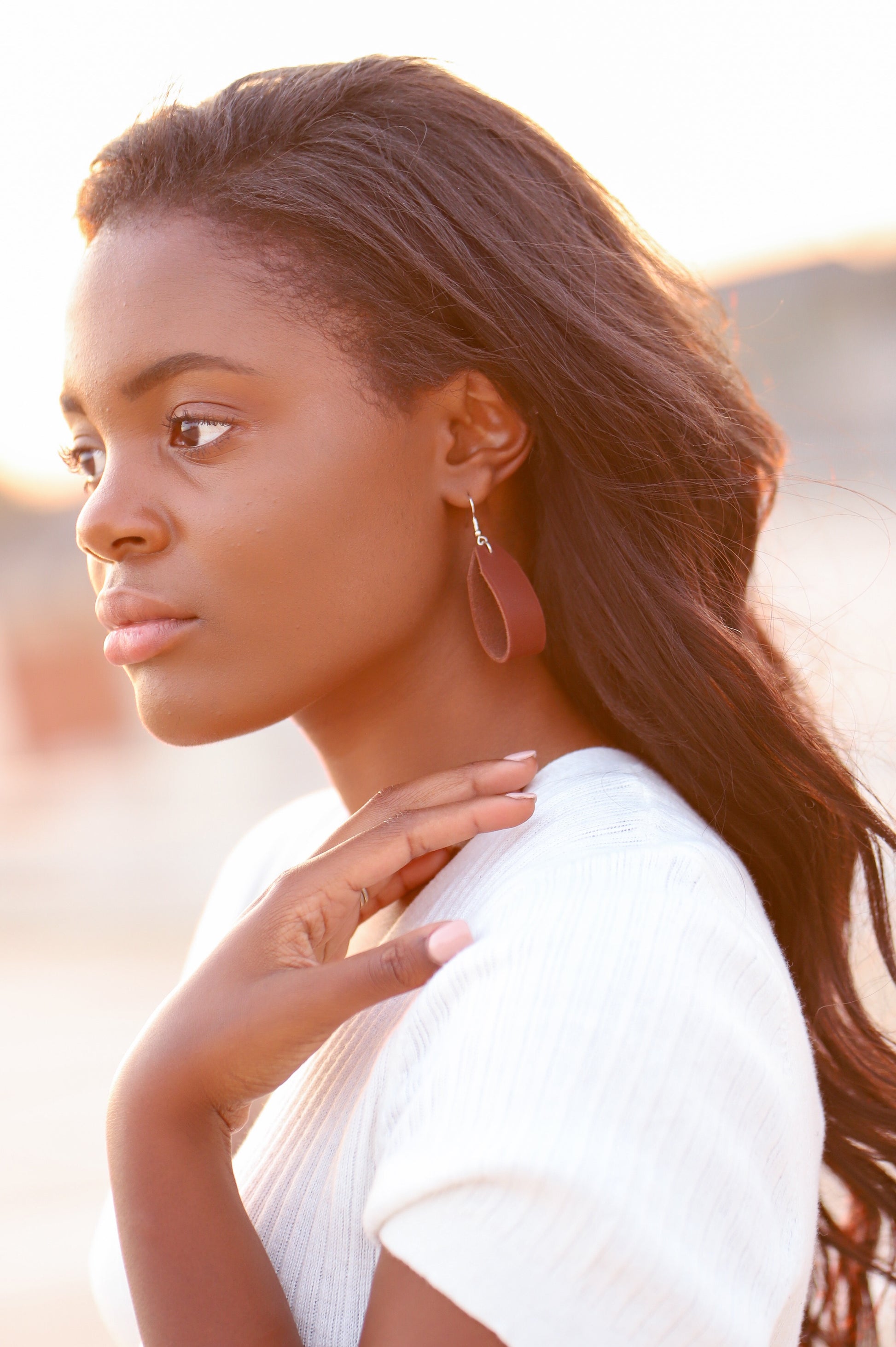 A woman wears the Urban Southern Leather Loop Everyday Earrings in Chestnut Brown.