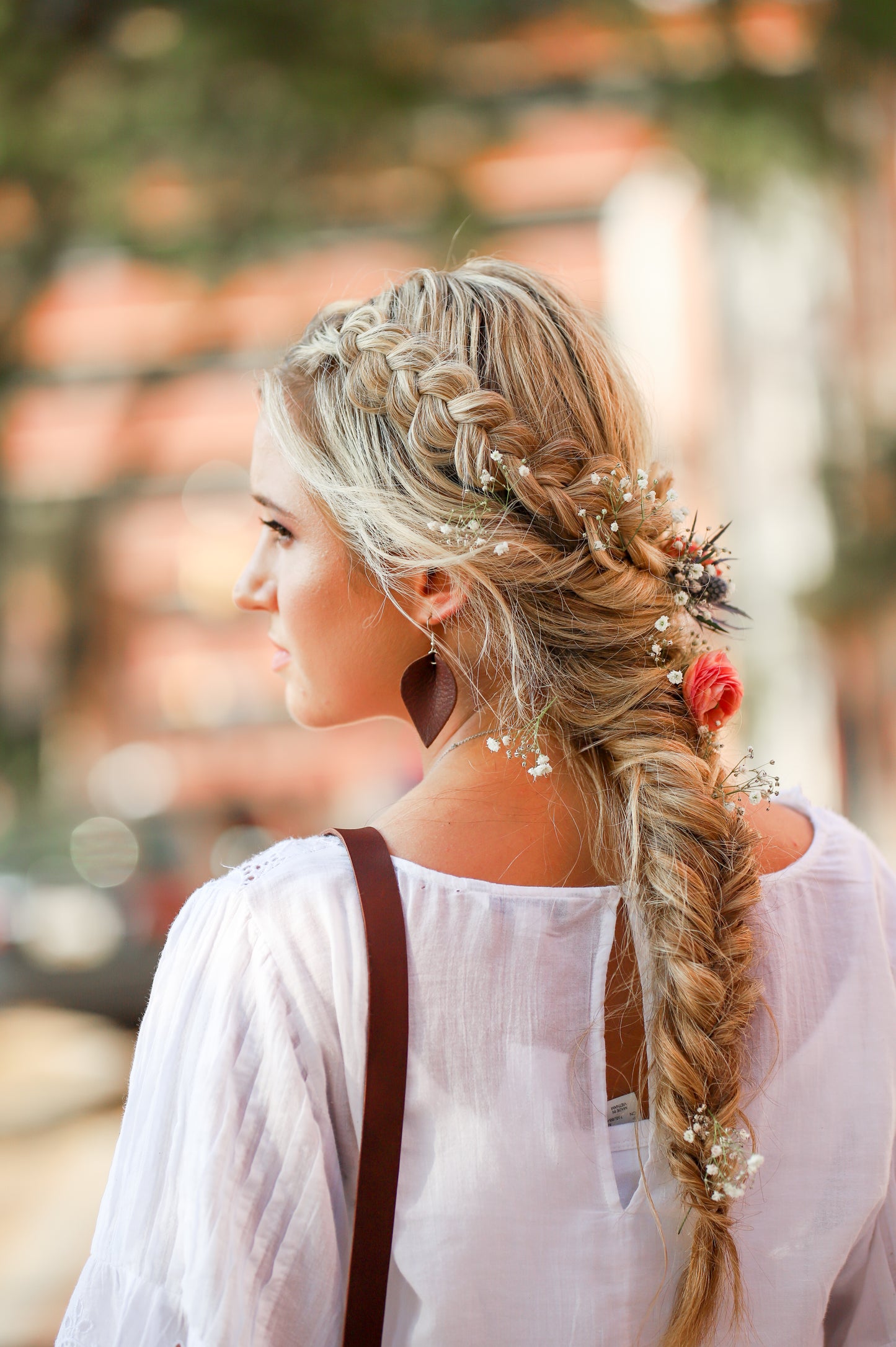 A woman wears the Urban Southern Leather Teardrop Everyday Earrings in Chestnut Brown.