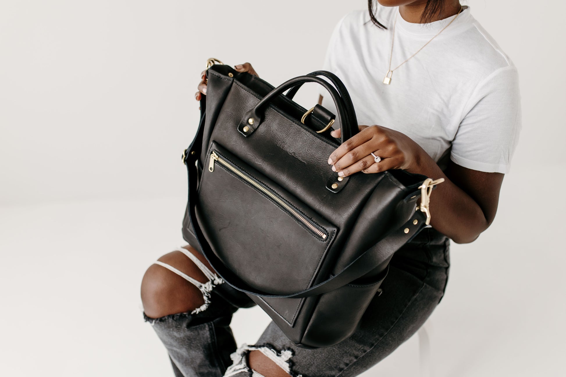 The Urban Southern Legacy Backpack Tote straps can easily switch into different carrying positions using the brass clips.