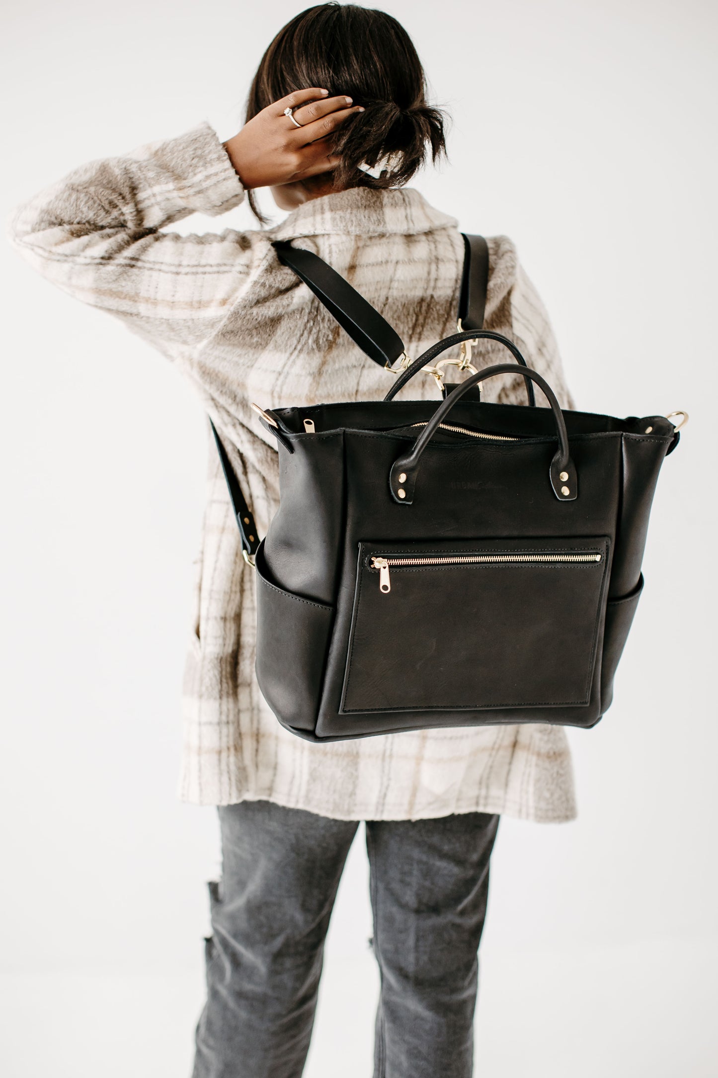 The Legacy Backpack Tote carried as a traditional backpack in Black.