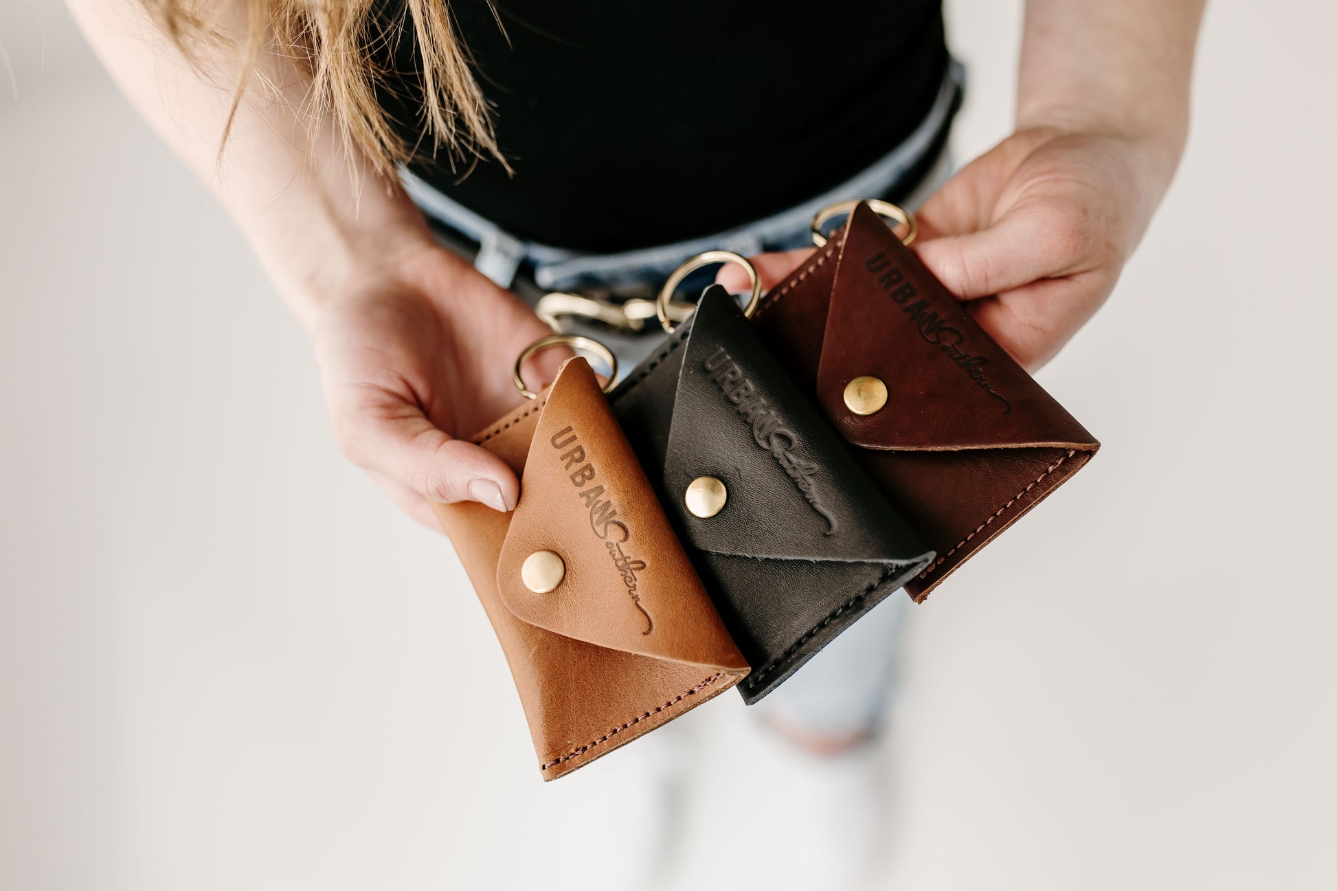 The Urban Southern Keychain Coin Purse is shown in three different colors: Honey, Black, and Chestnut Brown.