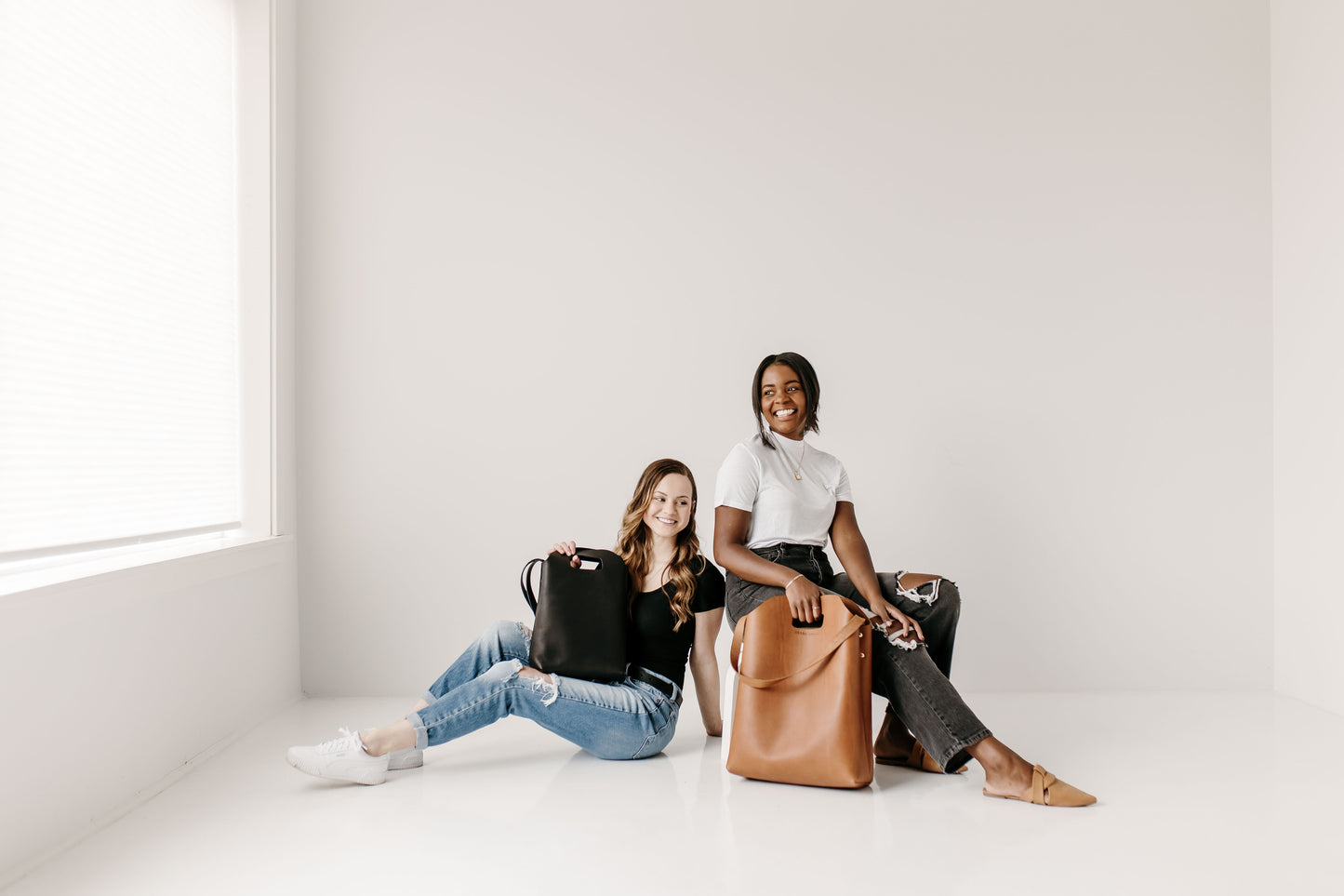 One woman holds the Market Tote while another woman holds the Urban Southern Mini Market Tote.