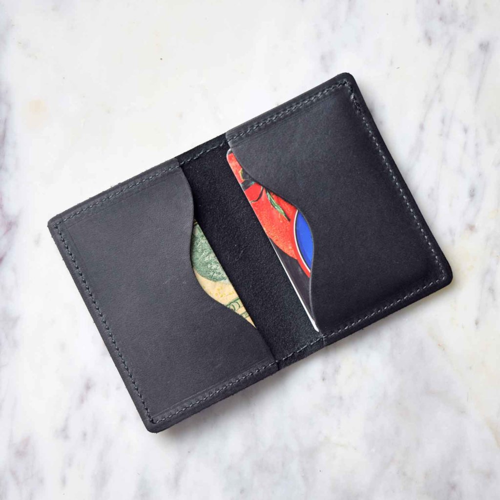 The Leather Bifold Card Wallet shown with folded cash and credit cards inside.