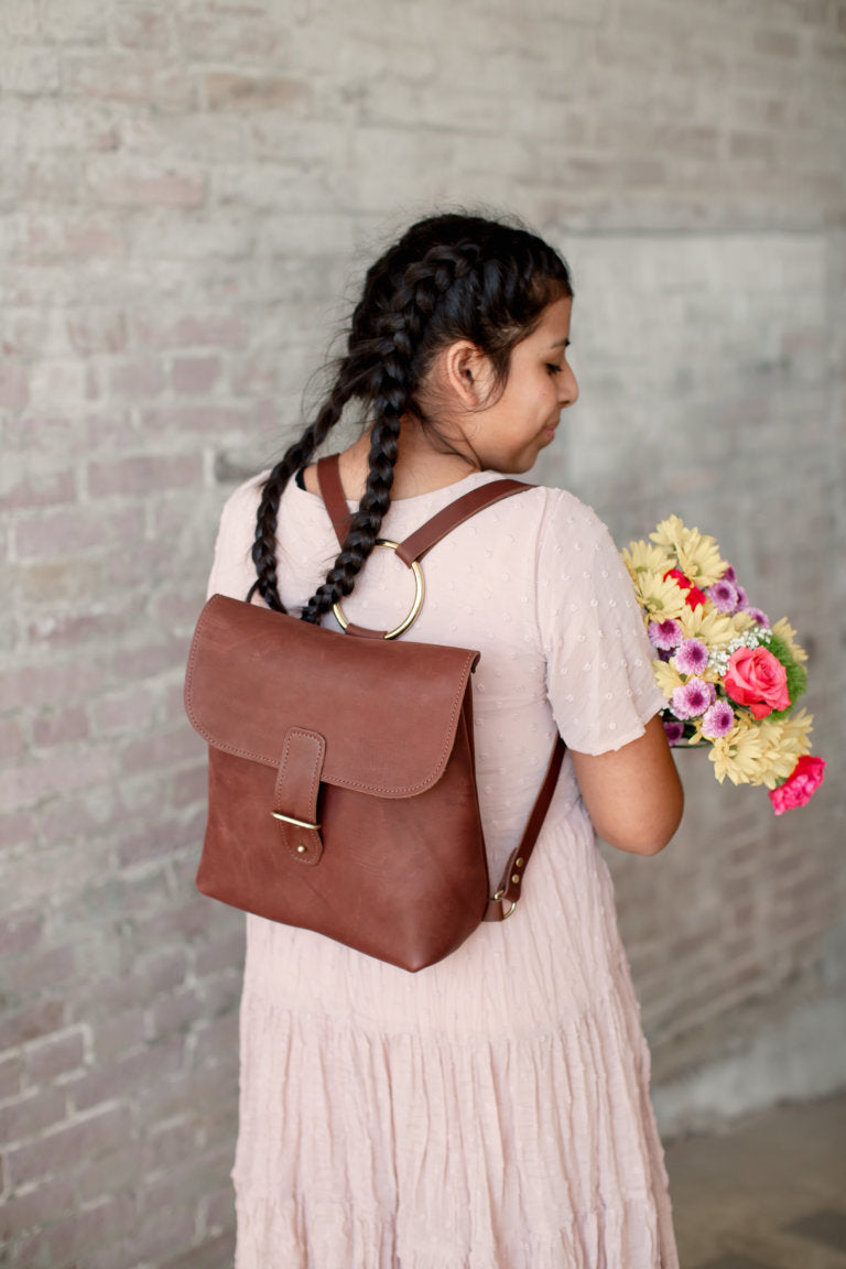 A woman carries the Monterey Backpack on her back.