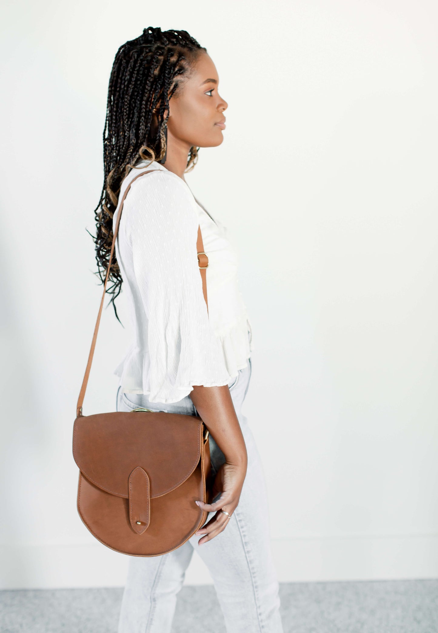 A woman carries the Heritage Saddlebag in Honey over her shoulder.