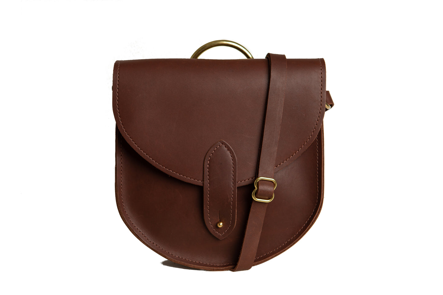 The Urban Southern handcrafted leather Heritage Saddlebag features a brass post closure, adjustable strap, and brass carrying handle. Shown here in Chestnut Brown.