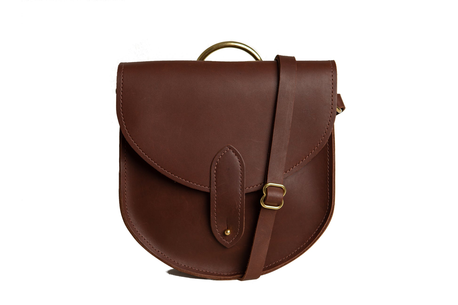 The Urban Southern handcrafted leather Heritage Saddlebag features a brass post closure, adjustable strap, and brass carrying handle. Shown here in Chestnut Brown.