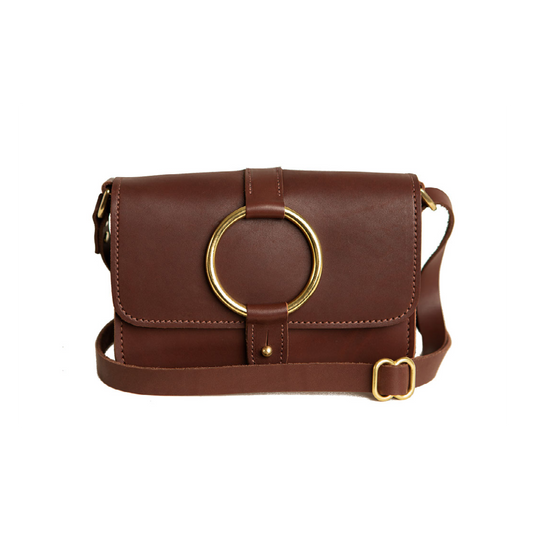 The Urban Southern handcrafted leather 5-Pocket Crossbody Bag in Chestnut Brown color, with handmade stitching, brass ring accent, brass post clasp, adjustable leather strap, and engraved Urban Southern logo.