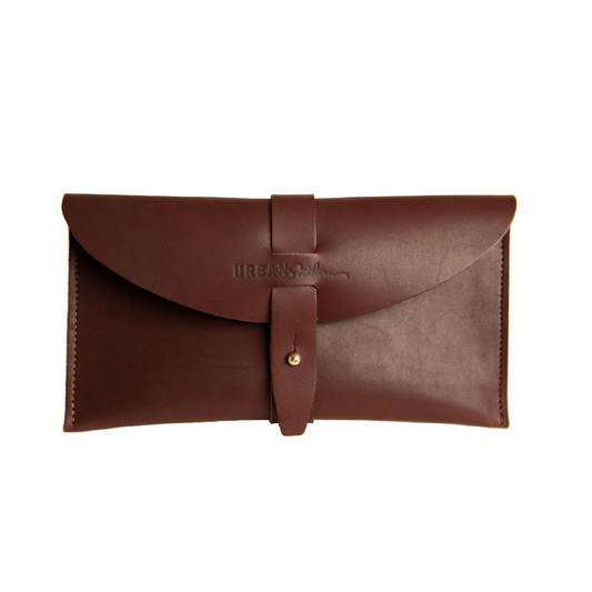The handcrafted leather 5th Avenue Clutch in Chestnut color, with handmade stitching, engraved Urban Southern logo, leather band and brass post clasp.