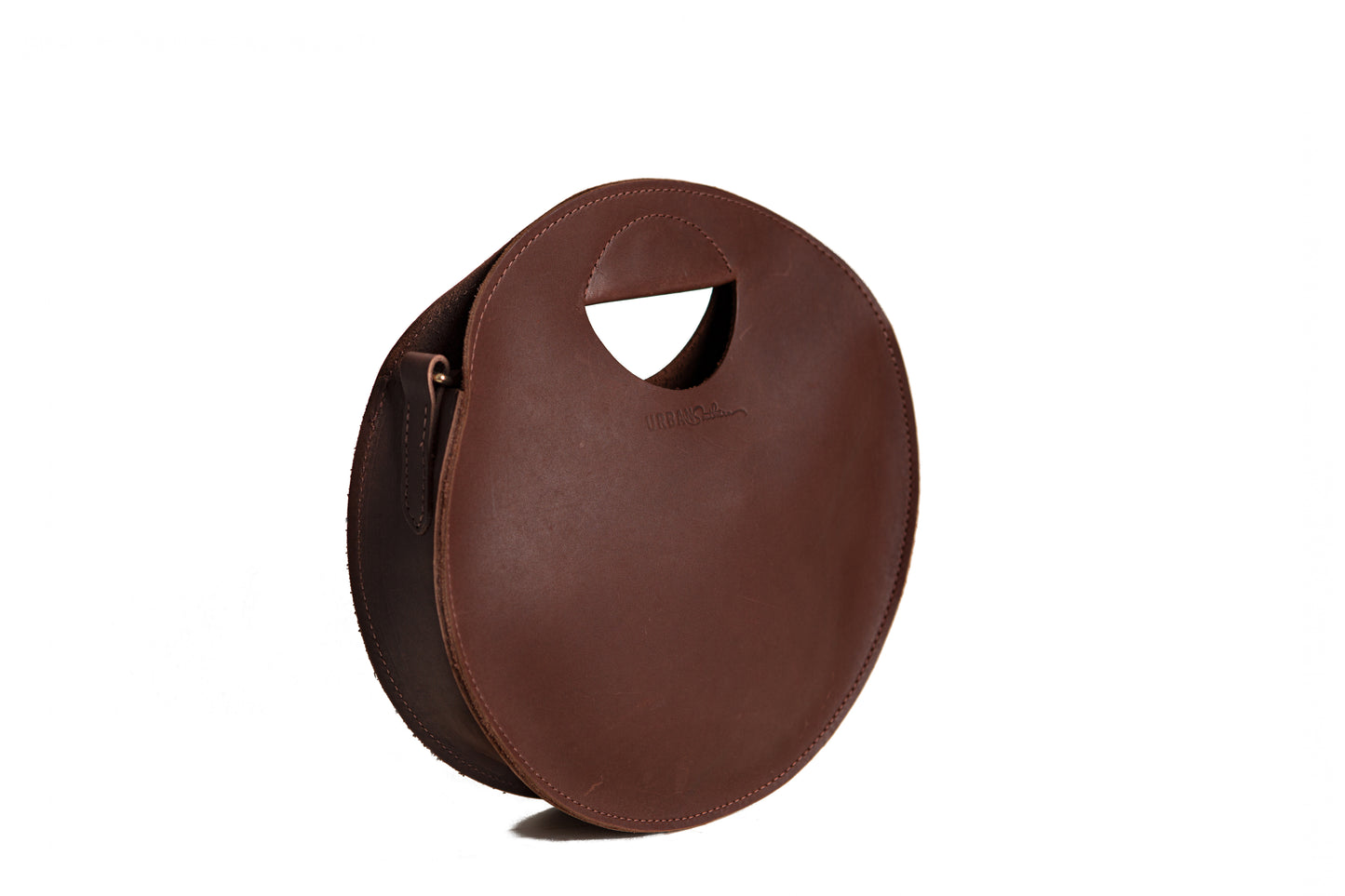 The adjustable strap on the Britt Circle Crossbody can be removed for hand-carrying only using the built-in handle.