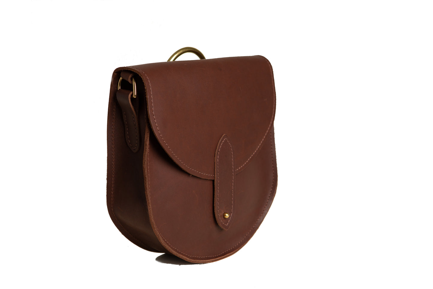 The side of the The Urban Southern handcrafted leather Heritage Saddlebag shows the depth of the curved bag, along with brass hardware.