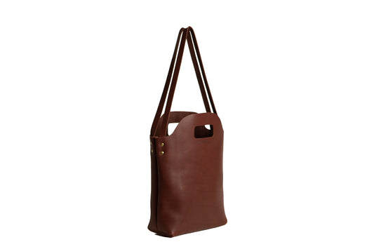 The Urban Southern handcrafted leather Mini Market Tote features brass accents and the Urban Southern logo engraved on the front.