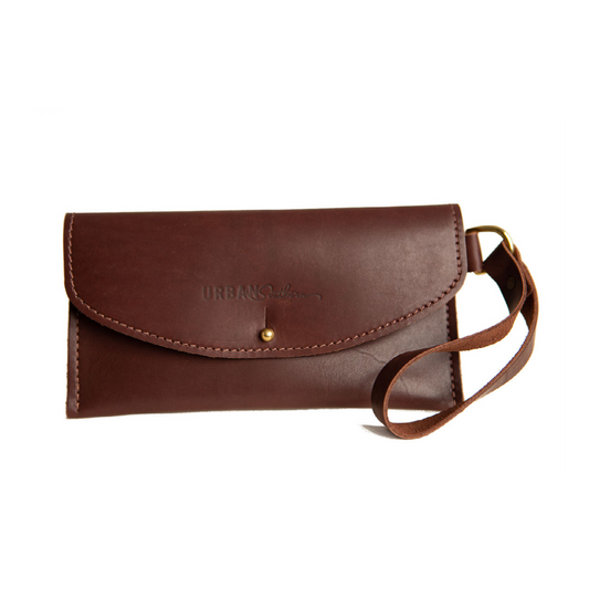 The Urban Southern handcrafted leather Wristlet Wallet with brass post closure, leather strap handle, and engraved Urban Southern logo, shown in Chestnut Brown.