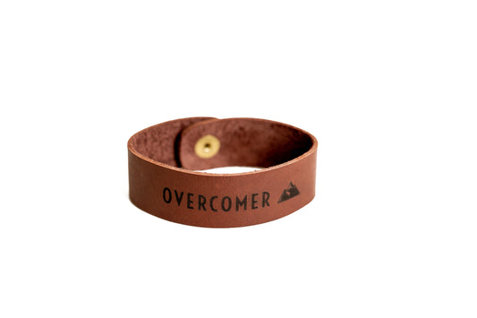 The leather Overcomer Cuff Bracelet comes in Chestnut Brown.