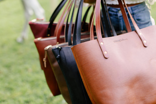 Close up of 5 leather totes in various shades, merlot, cognac, mocha, black, cognac 