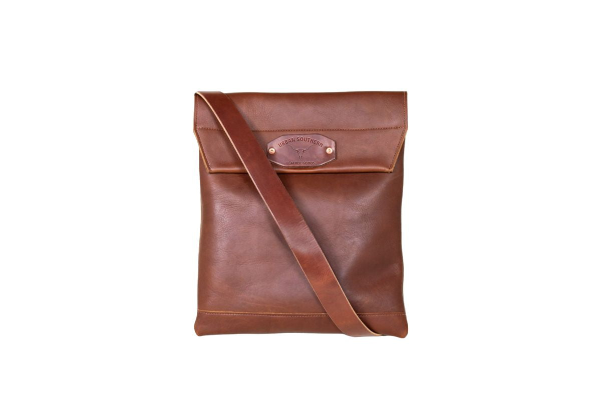 brown leather courier bag, featuring an adjustable strap and magnetic closure. 