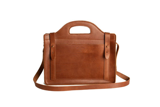Brown leather bsatchel with a shoulder strap on a white background